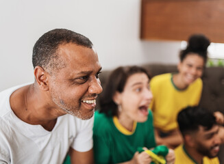 real latin american family watching football on television, celebrating goal of brazil