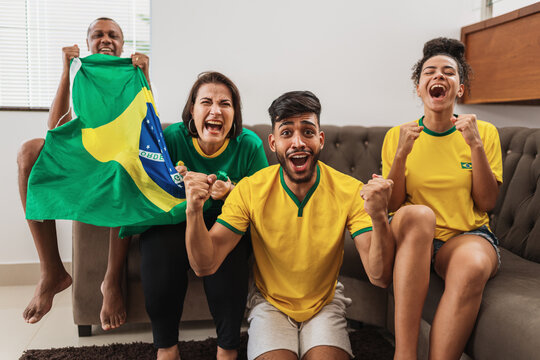 real latin american family watching football on television, celebrating goal of brazil