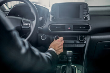 Close-up of male hands adjusting car settings