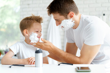 Father teaches his little son how to shave face