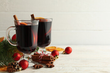 Cups of mulled wine and Christmas accessories on wooden background