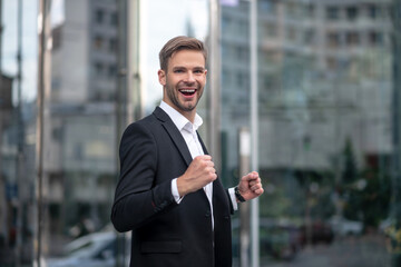 Young handsome businessman looking excited and happy
