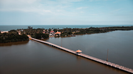 Obraz premium aerial view of small long bridge crossing river to island. a shelter on walking bridge. lonely pavilion