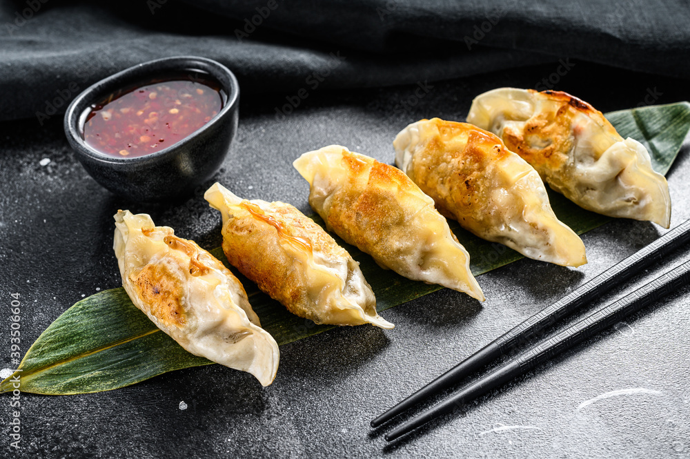 Wall mural Fried Japanese gyoza dumplings. Black background. Top view