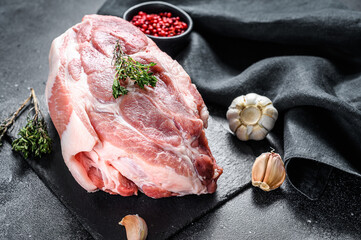 Raw pork neck chop meat with herb leaves and spices. Black background. Top view