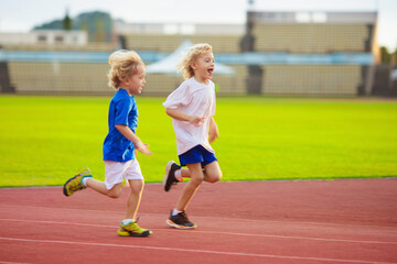Child running in stadium. Kids run. Healthy sport.