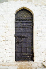 antique iron door on white stone wall background