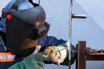 Welder qualification. The welder is welding with shielded metal arc welding process to steel plate...