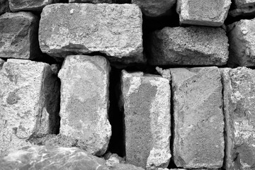 evocative black and white image of texture of old bricks stacked irregularly