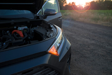 glowing headlight of a black car at sunset