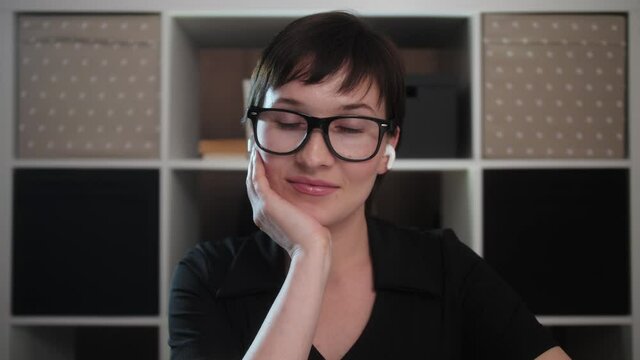 Young woman student wear wireless headphones learn watching online webinar webcast class looking at laptop e learning distance course or video calling teacher by webcam.