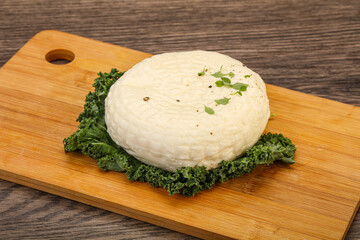 Caucasian suluguni round cheese piece