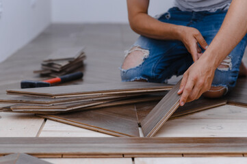 Man laying parquet flooring - closeup on male hands. worker joining parquet floor