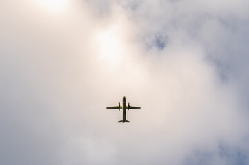 Twin-engine turboprop aircraft against a cloudy sky.