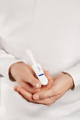 Man holding oral HIV test on white background.