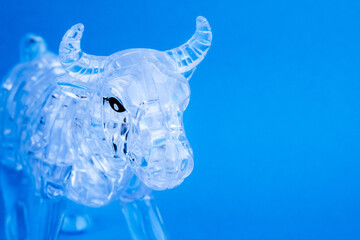 Figurine of a bull from three dimensional puzzles on blue background. Symbol of coming New Year...