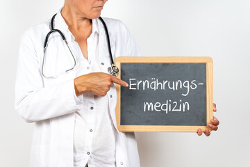 Ärztin mit einem Schild auf dem Ernährungsmedizin steht