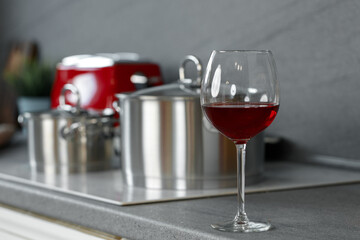 Still life photo of metal casseroles on induction stove in kitchen