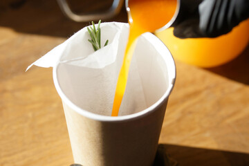 Black tea with sea buckthorn and rosemary in a paper cup