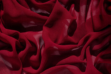 Smooth elegant burgundy chiffon fabric abstract background. Dark red wine silk satin luxury cloth...