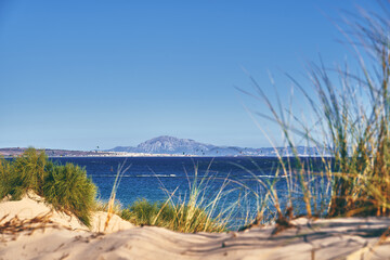 Closeup shot of Valdevaqueros dune with the view of Tarifa and Africa