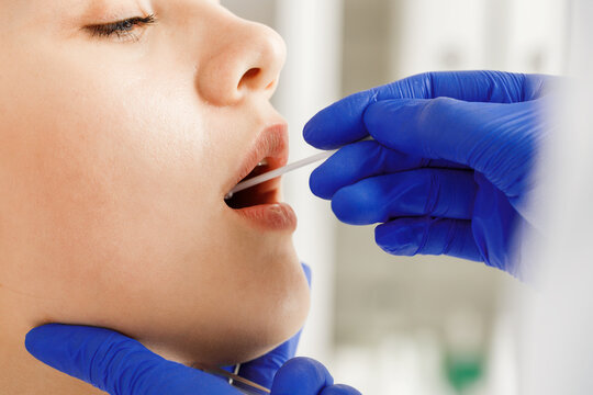 Doctor Taking A Throat Swab From A Patient Woman