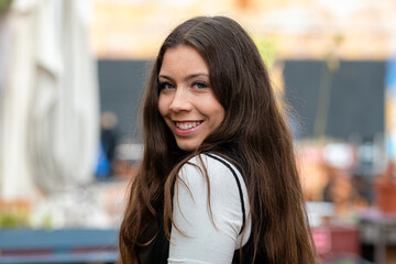 Obraz premium amazing, optimistic young woman with long hair on a blurry street background