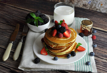 Pancakes, a glass of milk and honey.