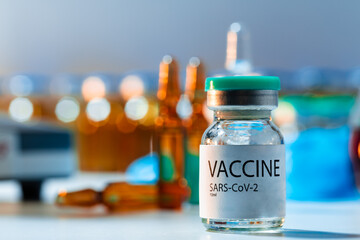 Vaccine vials of Sars-cov-2 on table in laboratory .