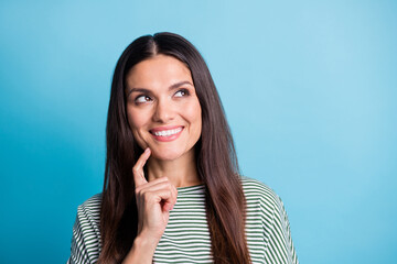 Portrait of attractive person finger on chin look empty space toothy smile isolated on blue color background © deagreez