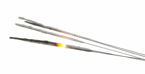 Sparklers burning and emitting flame, New Year's celebration pyrotechnic fireworks, isolated on white background with clipping path