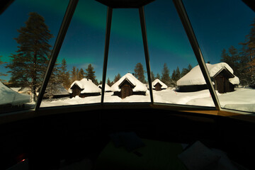 Aurora Borealis through the window of the igloo cabin in Finland Lapland. Arctic circle Christmas winter adventure, good luck and happiness 