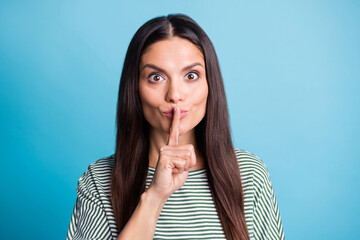 Photo of adorable cunning lady finger covering lips do not tell wear white green isolated on blue...