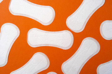Woman hygienic pads on orange background top view