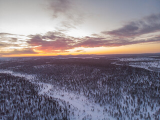 Aerial drone shot of the forest covered in snow winter and the village inside the Arctic Circle....