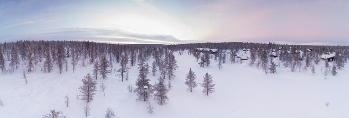 Visit Lapland Holidays. Aerial drone panorama shot of the forest covered in snow winter and the...