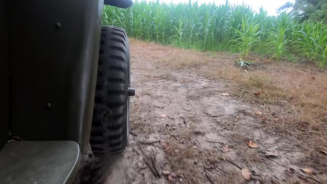 Military jeep car driving on dirt road, close up of wheel