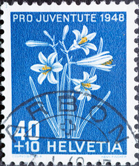 Switzerland - Circa 1948 : a postage stamp printed in the swiss showing a paradise lily (Paradisea...