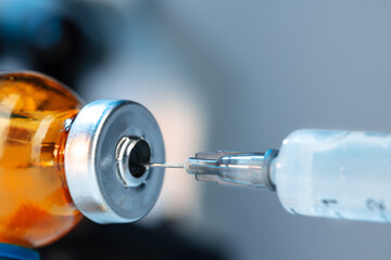 Vaccine bottle with a syringe taking the vaccine from it