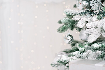 Christmas minimal background, a tree decorated with balls on a background of blurry bokeh lights.