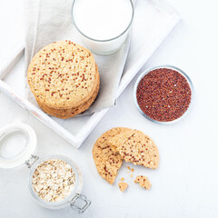 Oatmeal and red quinoa cookies on a table and white tray, top view, square