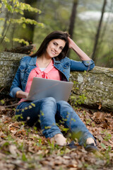 Junge Frau mit Laptop im Wald