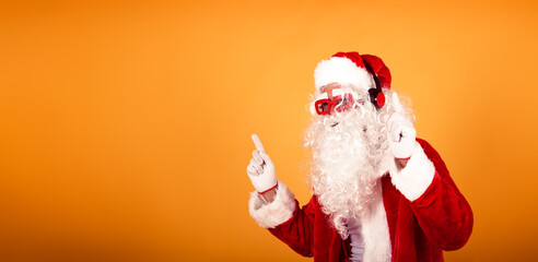 Fototapeta na wymiar santa claus on party mode. dancing moving listens to music with headphones. cool christmas concept in a banner for blog, internet sites, and advertising