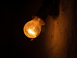 Old bulb lamp glowing in the dark. Beautiful dusty vintage lights decor on the wall. Retro style...