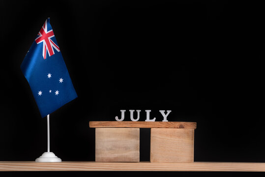 Wooden calendar of July with Australian flag on black background. Holidays of Australia in July.