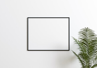 Horizontal 8x10 Black Frame mockup. Horizontal Black frame on a white wall with plant leaves.