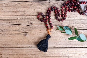 Close up of a prayer beads (mala) for chanting mantras as a decoration on an old wooden board