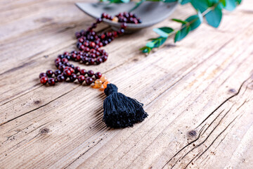 Close up of a prayer beads (mala) for chanting mantras as a decoration on an old wooden board