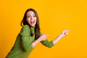 Photo of funny lady direct fingers side empty space showing sale wear green pullover isolated yellow color background