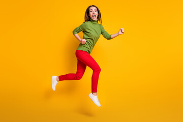 Full size profile photo of crazy lady jump up rush wear casual green pullover shoes red trousers isolated yellow color background